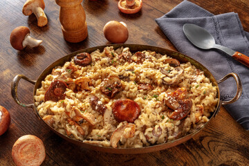Mushroom risotto, rustic mushroom rice, with ingredients, on a wooden table