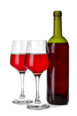 Glasses and bottle of delicious red wine on white background