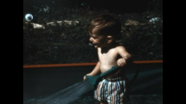 Water Fight 1953 - Parents play with their son in a kiddie pool.  