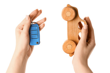 Woman with wooden car and key on white background