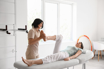Female physiotherapist working with young woman in rehabilitation center