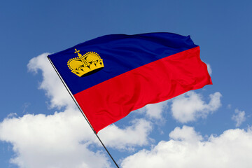 Liechtenstein flag isolated on the blue sky background. close up waving flag of Liechtenstein. flag symbols of Liechtenstein. Concept of Liechtenstein.