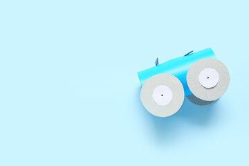 Figure of car made of cardboard tube for toilet paper on color background