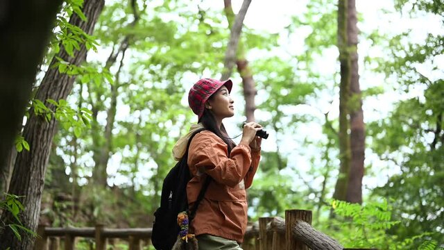 森で野鳥観察をする女性