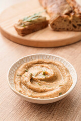 Bowl with tasty baba ghanoush on wooden background, closeup