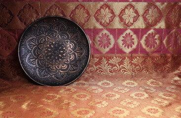 Bronze plate in oriental style on a background of dark red and gold, a magnificent century