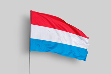 Luxembourg flag isolated on the blue sky background. close up waving flag of Luxembourg. flag symbols of Luxembourg. Concept of Luxembourg.