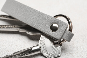 Keys with leather keychain on light background, closeup