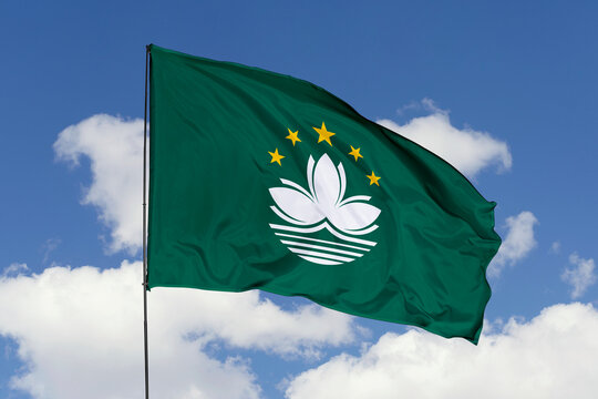 Macau flag isolated on the blue sky background. close up waving flag of Macau. flag symbols of Macau. Concept of Macau.