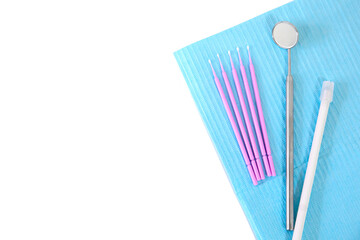 Dental instruments, microbrushes lie on a white table on a napkin. Care and prevention concept. Blank space for an inscription.