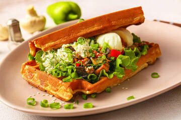 Delicious Belgian waffles with egg and vegetables in plate on table, closeup