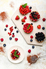Composition with tasty berry tartlets on white background