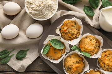 Composition with tasty spinach muffins on wooden background