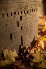 An ancient burial, a gravestone covered with fallen autumn leaves. An old grave. Ancient cemetery