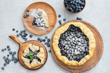 Composition with tasty blueberry galettes on light background