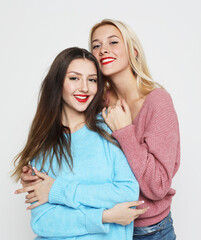 Lifestyle, emotion and people concept: two young women friends over white background