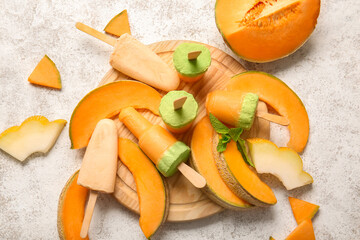 Board with tasty melon popsicles on light background
