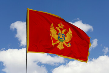 Montenegro flag isolated on the blue sky background. close up waving flag of Montenegro. flag symbols of Montenegro. Concept of Montenegro.