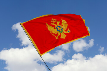 Montenegro flag isolated on the blue sky background. close up waving flag of Montenegro. flag symbols of Montenegro. Concept of Montenegro.