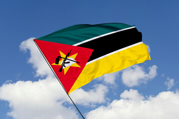 Mozambique flag isolated on the blue sky background. close up waving flag of Mozambique. flag symbols of Mozambique. Concept of Mozambique.
