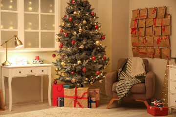 Christmas tree, gift boxes, armchair and advent calendar on wall in room