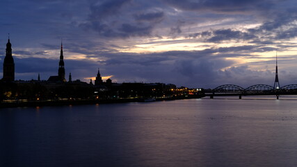 Autumn sunrise in Riga over the Daugava river against the background of the old town and the railway bridge