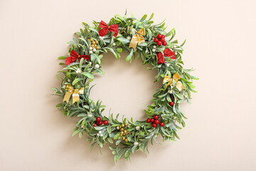 Fototapeta na wymiar Beautiful mistletoe wreath on color wall