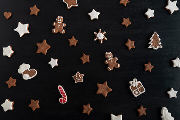 Gingerbread man and stars on black background. Traditional pastries.