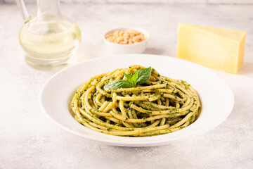 Pasta spaghetti with pesto sauce and fresh basil leaves