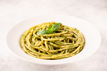 Pasta spaghetti with pesto sauce and fresh basil leaves