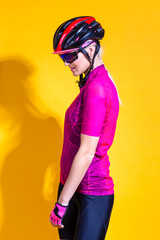 Female Cycling Ideas. Portrait of Sensual Female Road Cyclist in Professional Sport Outfit Posing Against Yellow Background.