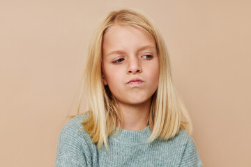 Beautiful little girl in a sweater, grimaces cropped view