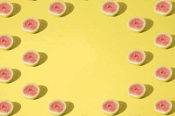 Arranged yellow fig half cutted on pastel background. Minimal design. Pattern. Copy space.