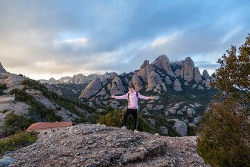 Naklejka premium The young man looks at the mountains. Landscape with mountains and tourist Montserrat Spain.