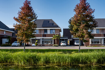 Dutch Suburban area with modern family houses, newly build modern family homes in the Netherlands, dutch family house, apartment house. Netherlands, newly build street with modern house - obrazy, fototapety, plakaty