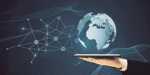 Close up of businessman hand holding tablet with glowing globe hologram with polygonal mesh on blue background. Global network and internet concept. © Who is Danny
