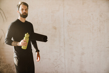 Mid aged bearded white man holding water bottle