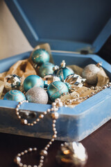 Christmas balls and beads in a box. Christmas decorations in blue and silver colors. New Year. Card