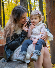 Pregnant woman with baby in autumn park