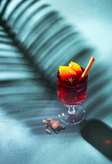 Hot mulled wine with fruits and spices in a glass, top view. Christmas and holidays festive background