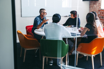 Creative businesspeople having a discussion in a meeting room - obrazy, fototapety, plakaty