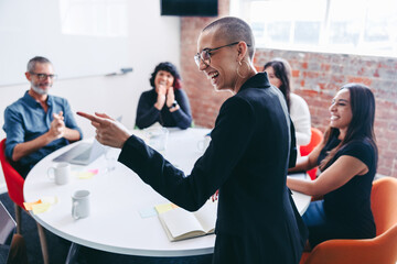 Black businesswoman receiving praise from her colleagues in an o