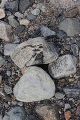 Rocks and pebbles of residual moraine at the beach on coast of Jomfruland Island in Norway