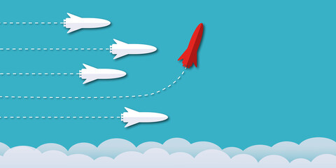 Red rocket among the white rockets changed direction on blue background as metaphor for business creativity new idea to discovery innovation technology. Space for the text. paper art design style.