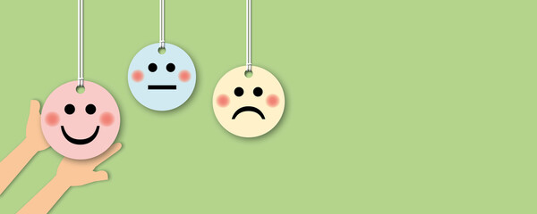 Hand choose holding pink happy face circle with colour circles on green background, positive thinking, mental health assessment, world mental health day concept, paper art design style.