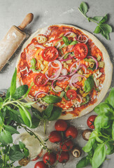 Pizza preparation with salami, tomatoes, mushrooms, onion, basil, cheese , fresh herbs and rolling...