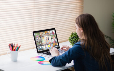 Caucasian girl using laptop for video call, with smiling diverse elementary school pupils on screen