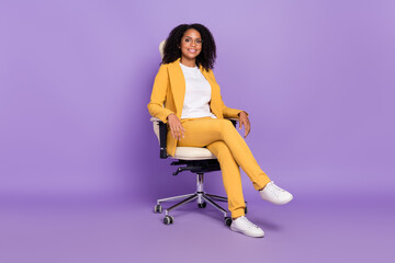 Photo of cute sweet lady wear yellow suit glasses smiling sitting office chair isolated purple...