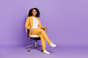 Photo of dreamy shiny woman dressed yellow suit spectacles sitting chair empty space isolated...