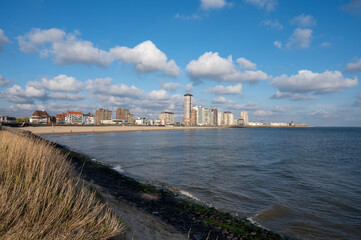 Fototapeta na wymiar Waterfront, dunes and view on Vlissingen city with sandy beach on sunset